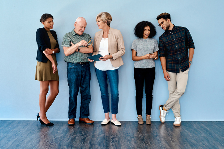 Young adults standing against s blue wall