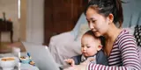 Mother looking at laptop with baby on her lap